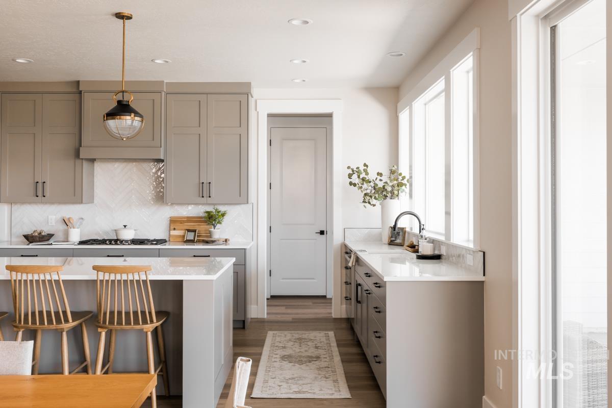 Kitchen with healthy amount of natural light, gray cabinets, light countertops, wood finished floors, and recessed lighting