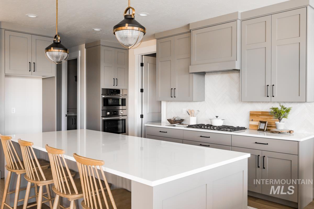 Kitchen featuring gray cabinetry, decorative backsplash, a kitchen island, light countertops, and recessed lighting