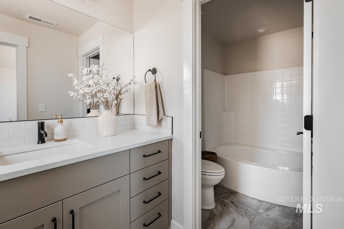 Full bathroom with marble finish floors and vanity