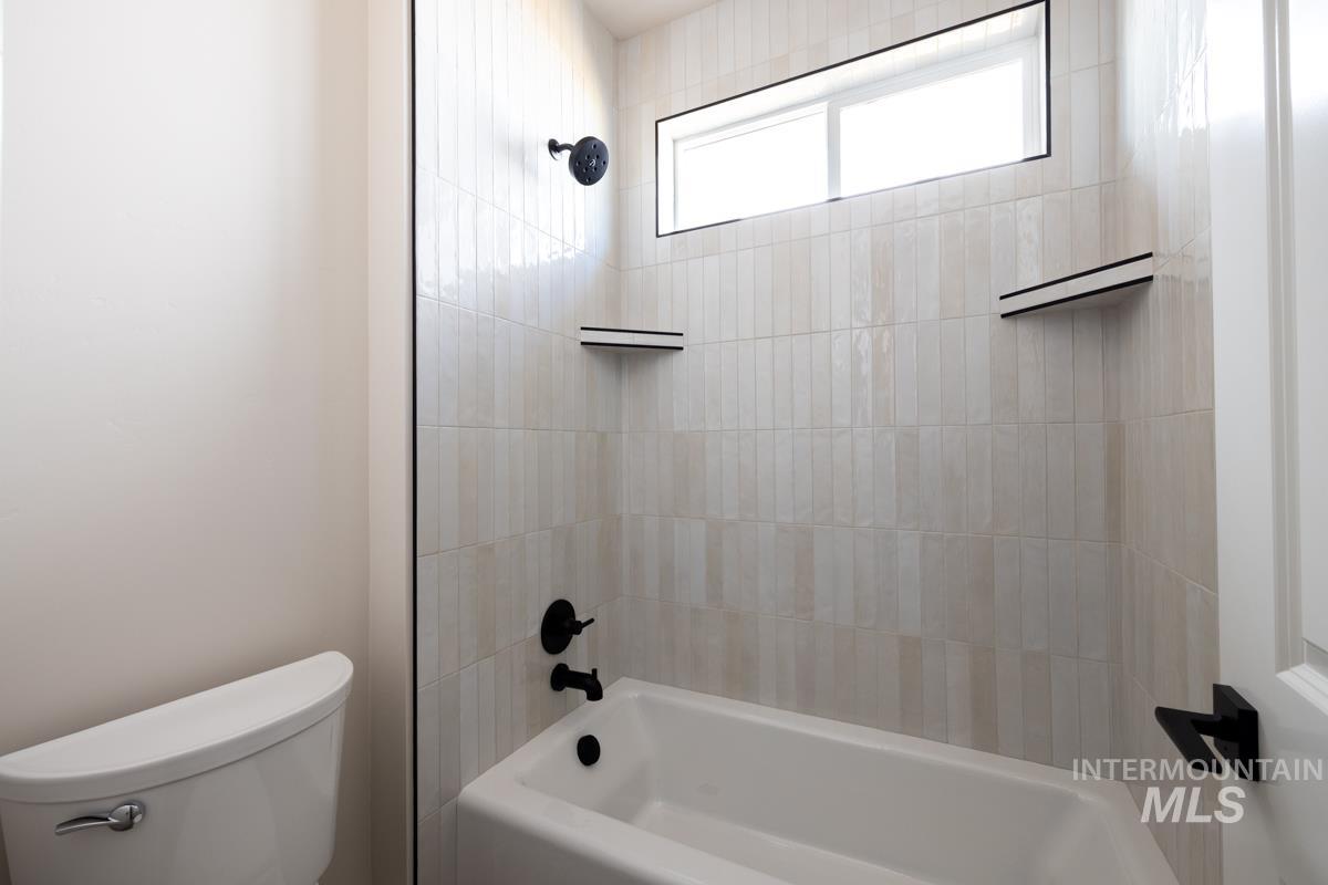 Full bathroom with toilet and washtub / shower combination