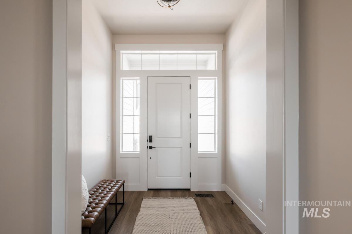 Entryway with dark wood finished floors and baseboards