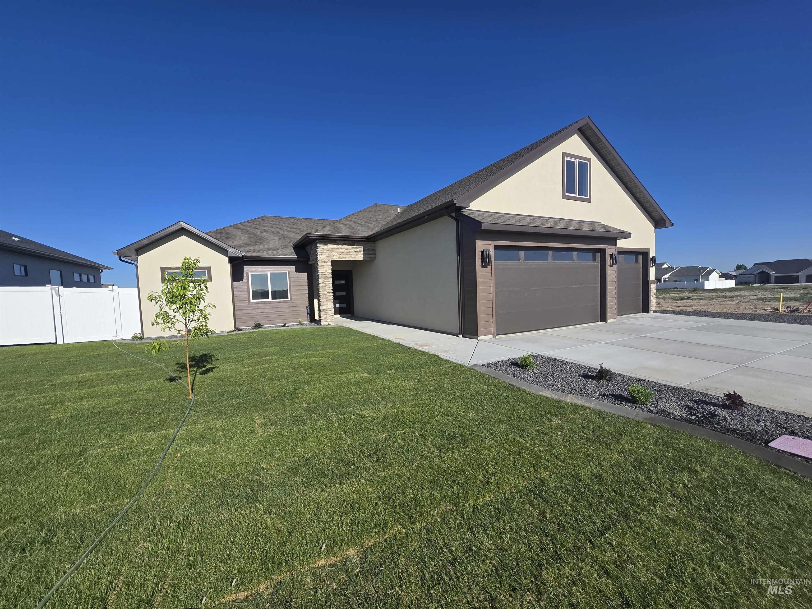 Ranch-style home featuring concrete driveway, stucco siding, and an attached garage
