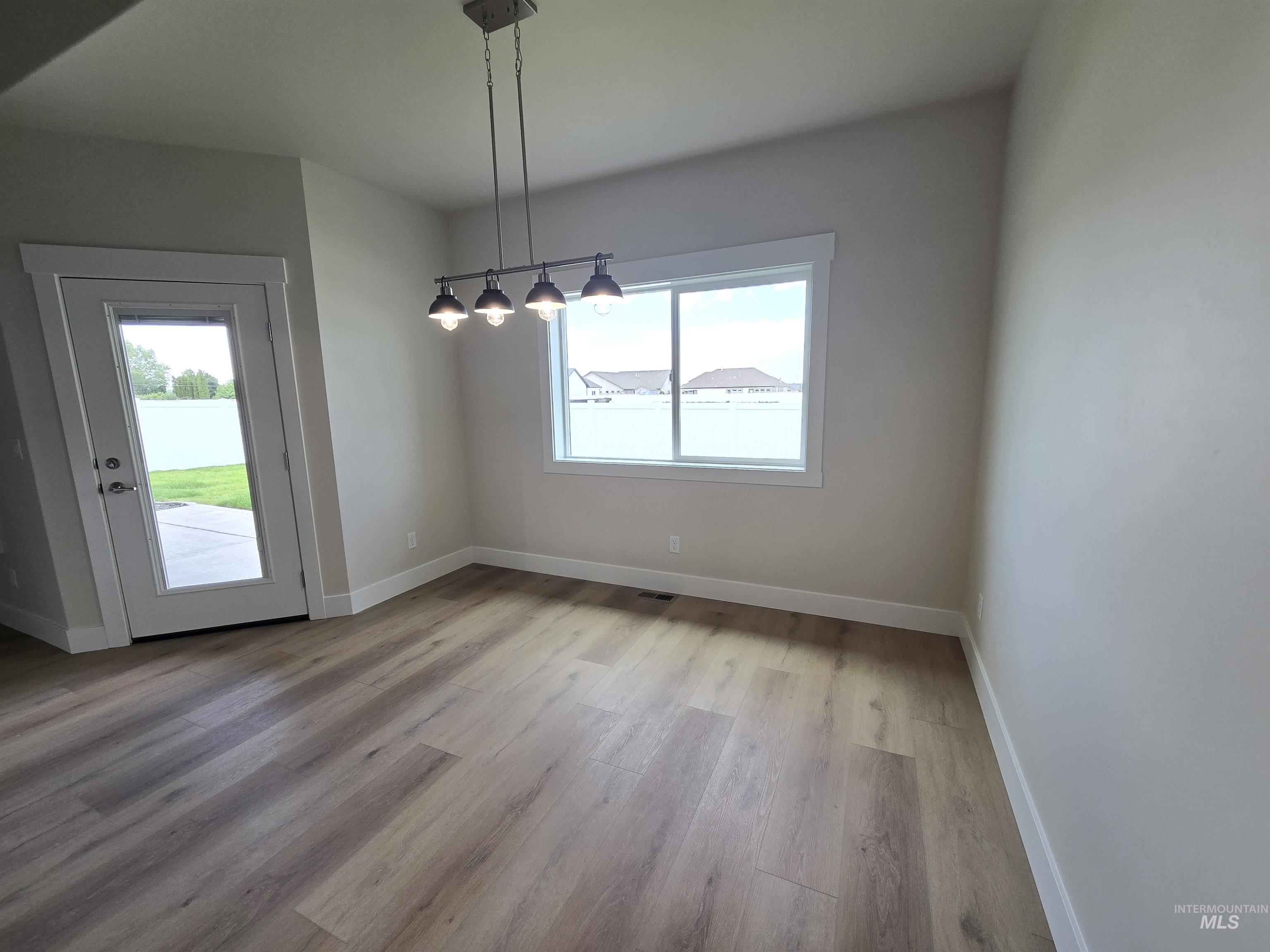 Unfurnished dining area featuring plenty of natural light and wood finished floors
