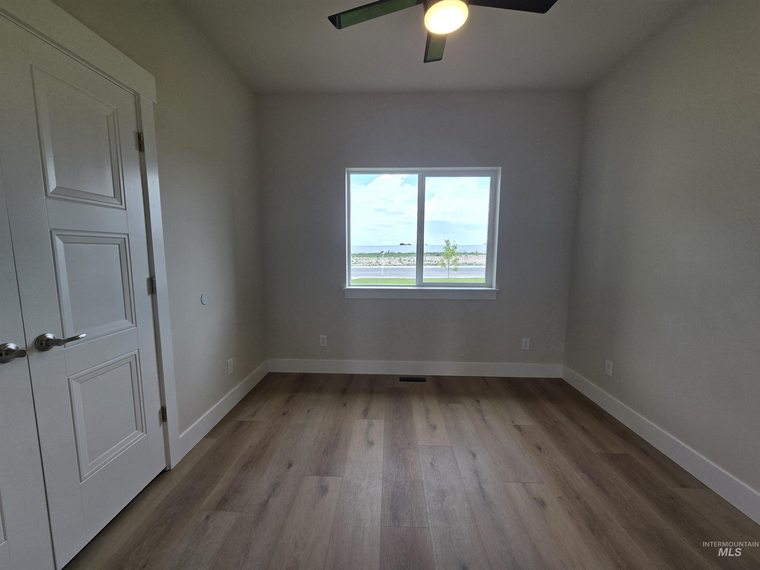 Spare room with a ceiling fan and wood finished floors