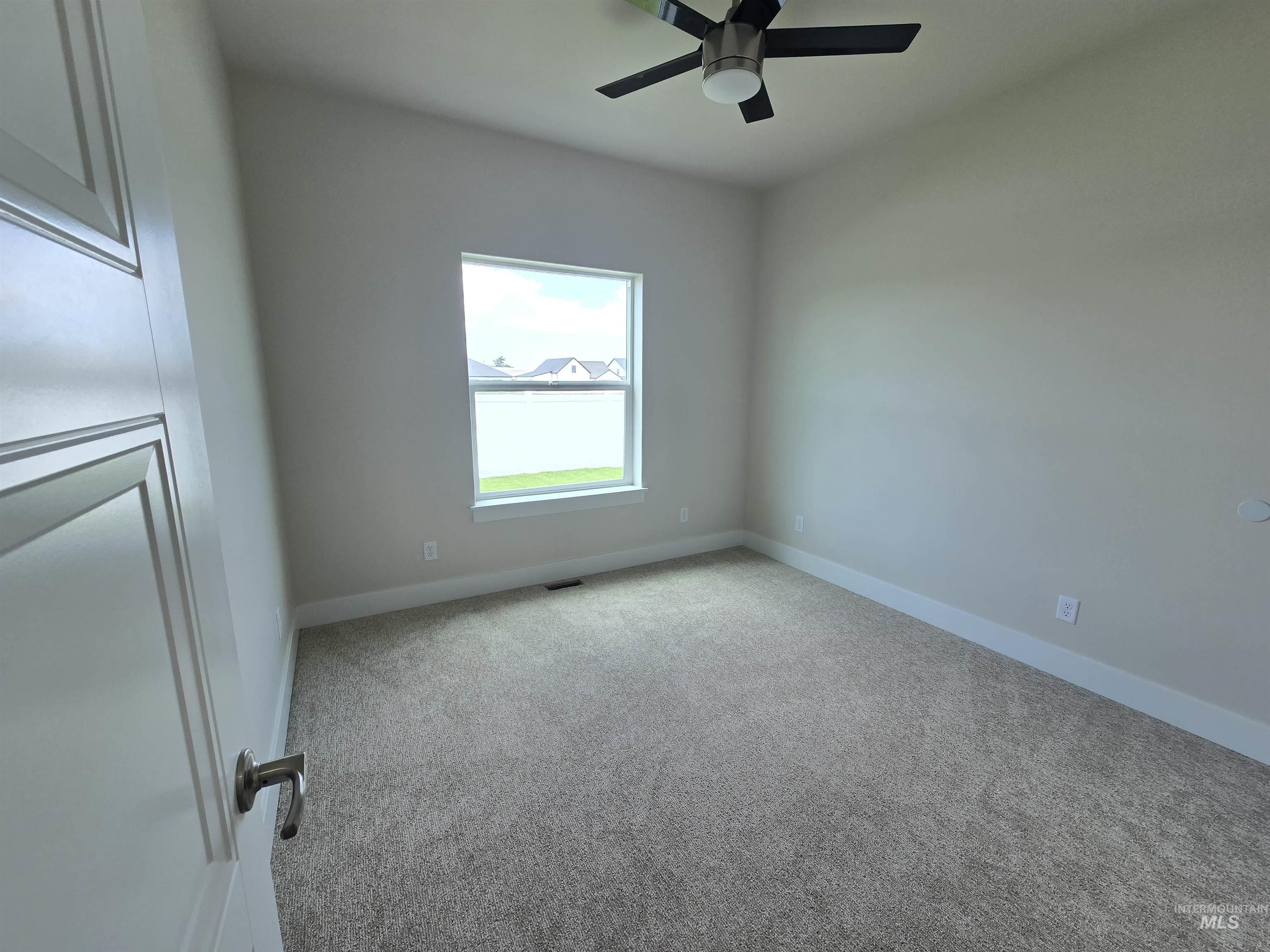 Empty room featuring carpet floors and a ceiling fan