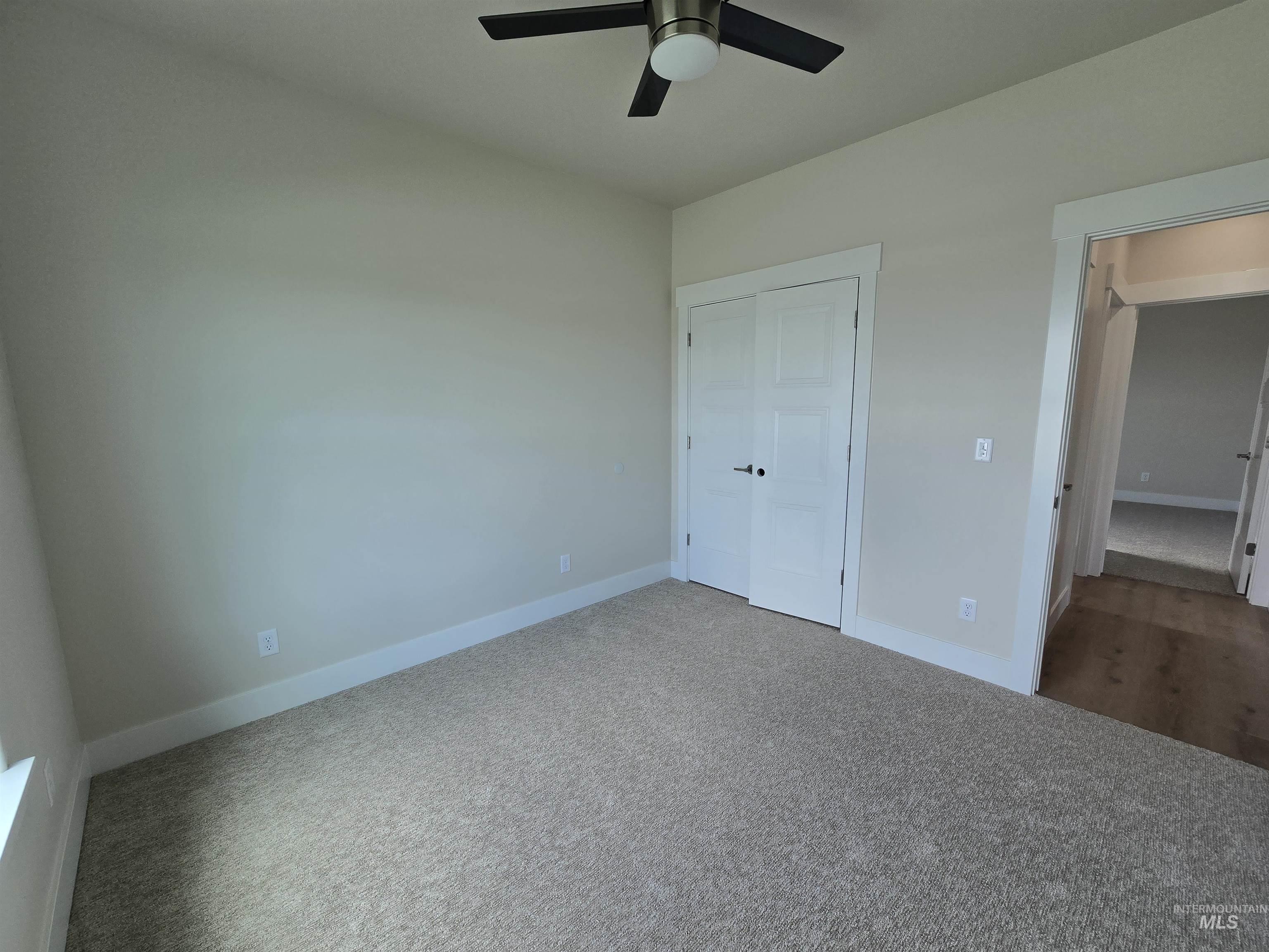 Unfurnished bedroom featuring carpet floors, a closet, and a ceiling fan