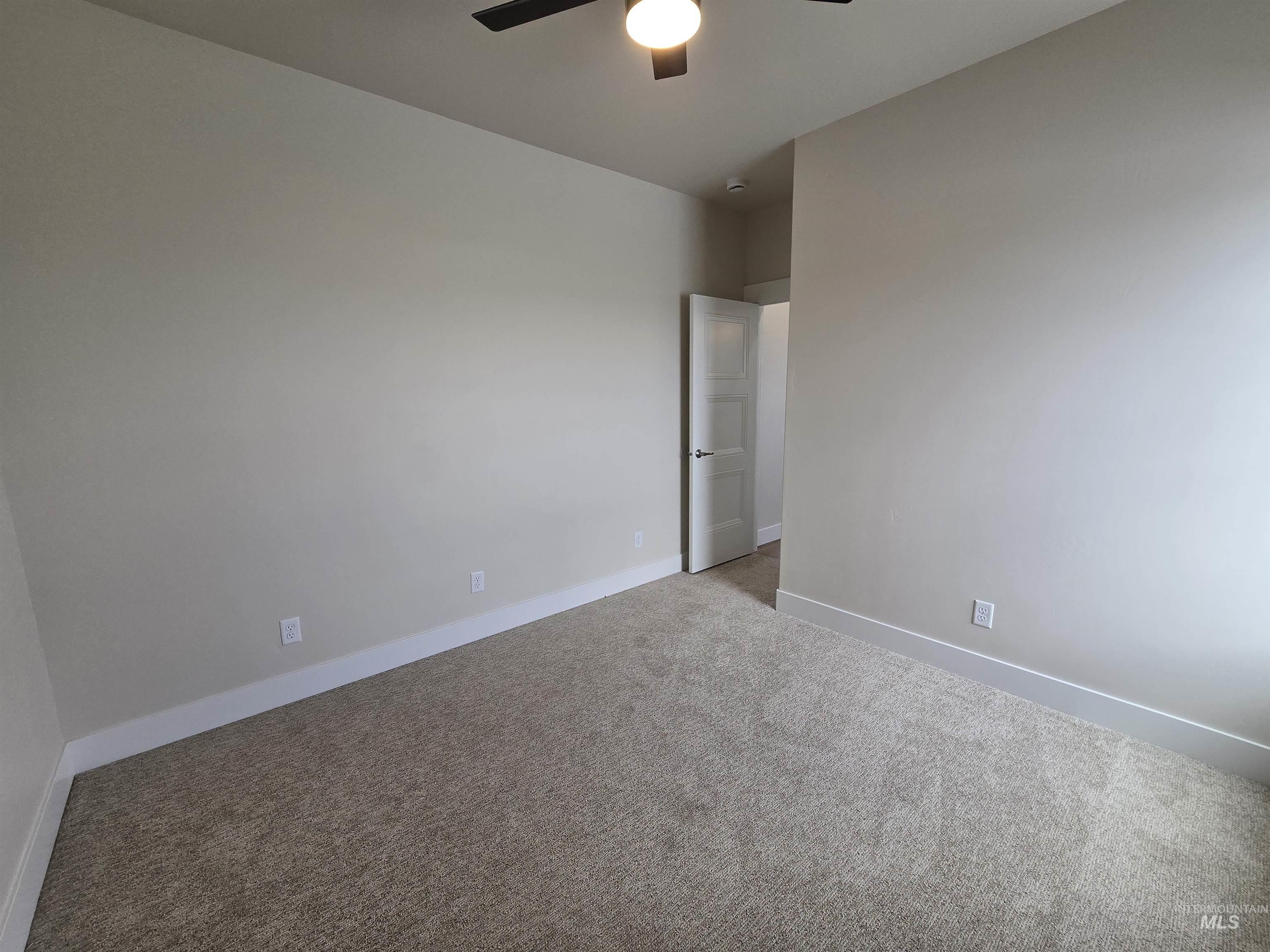 Unfurnished room featuring a ceiling fan and light colored carpet