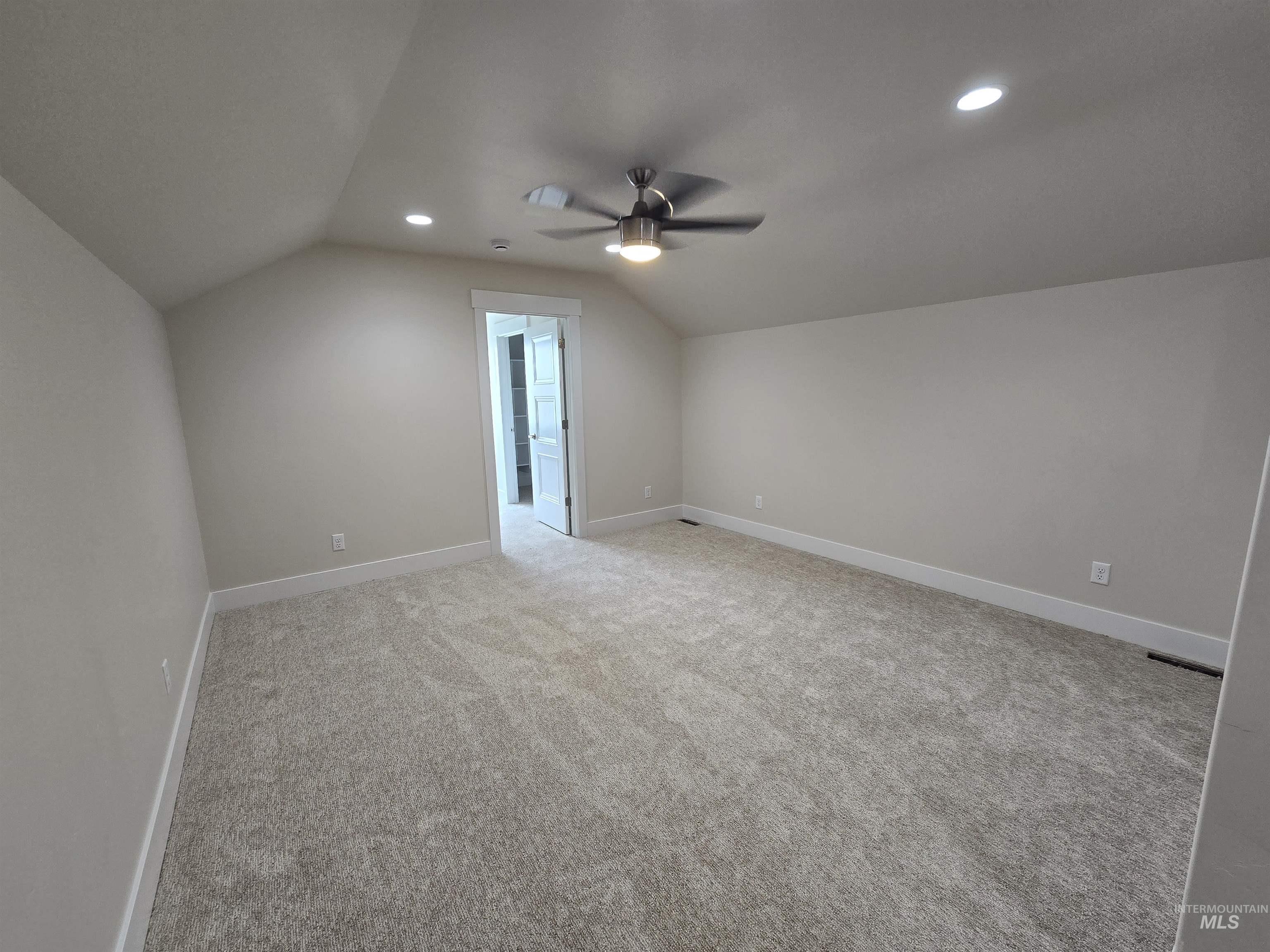 Additional living space featuring a ceiling fan, lofted ceiling, light colored carpet, and recessed lighting