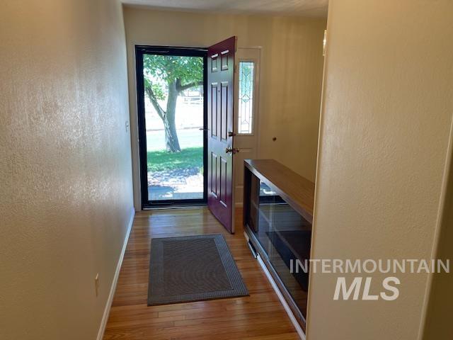 Entryway featuring light wood finished floors and a textured wall