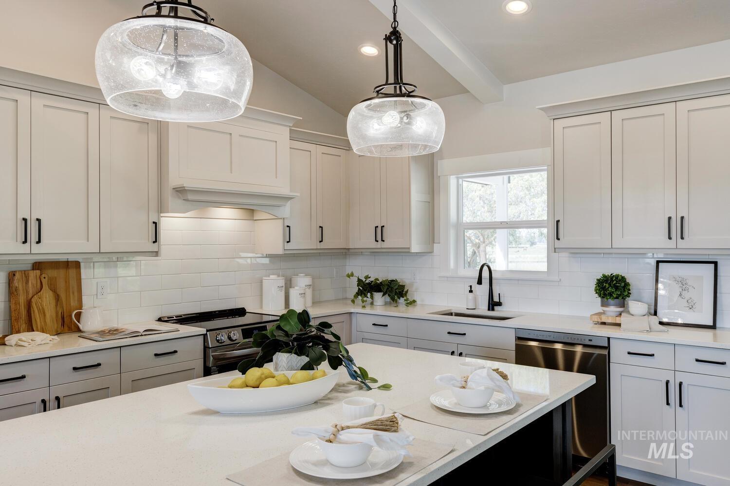 Kitchen featuring light countertops, appliances with stainless steel finishes, hanging light fixtures, tasteful backsplash, and recessed lighting