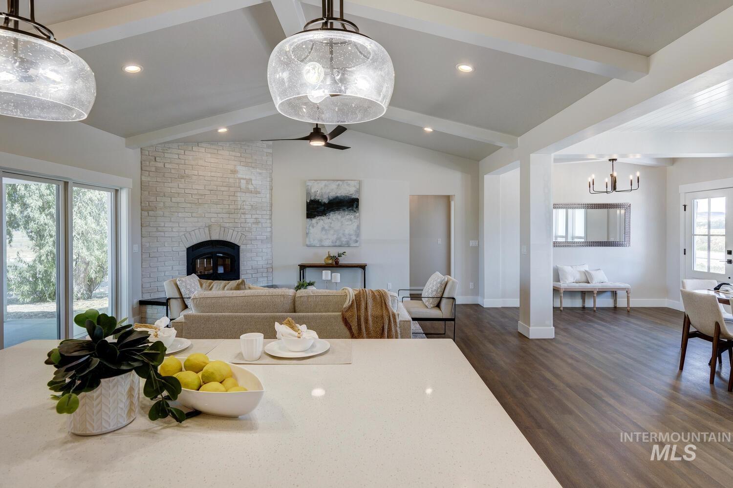Dining space with dark wood-type flooring, a brick fireplace, a chandelier, and recessed lighting