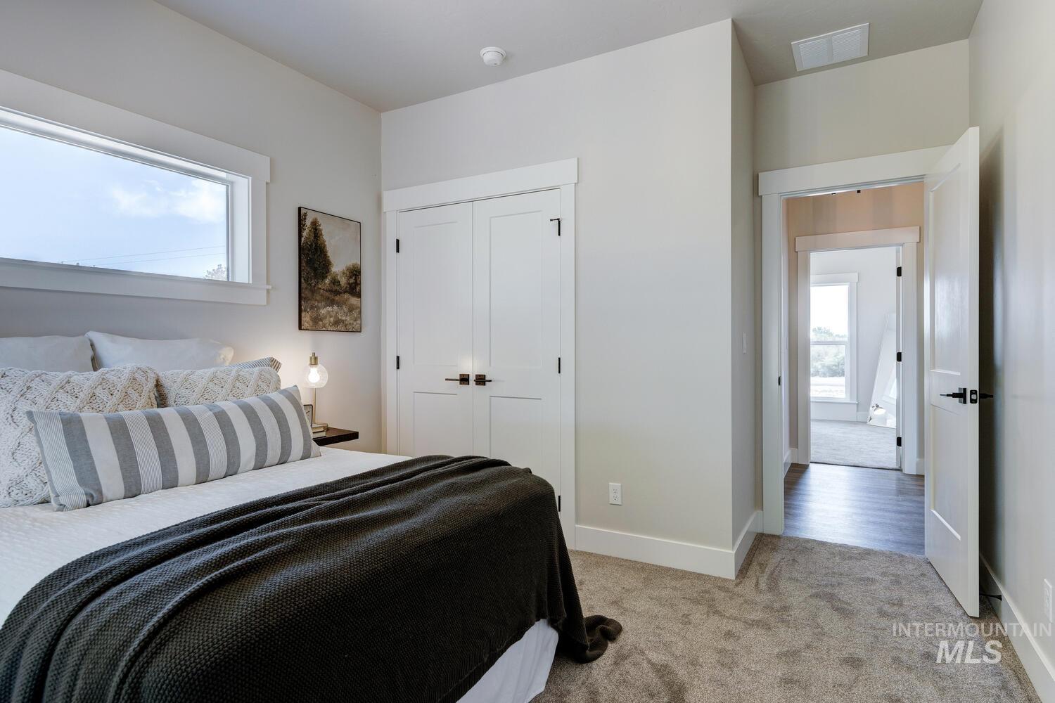 Bedroom with light carpet and a closet