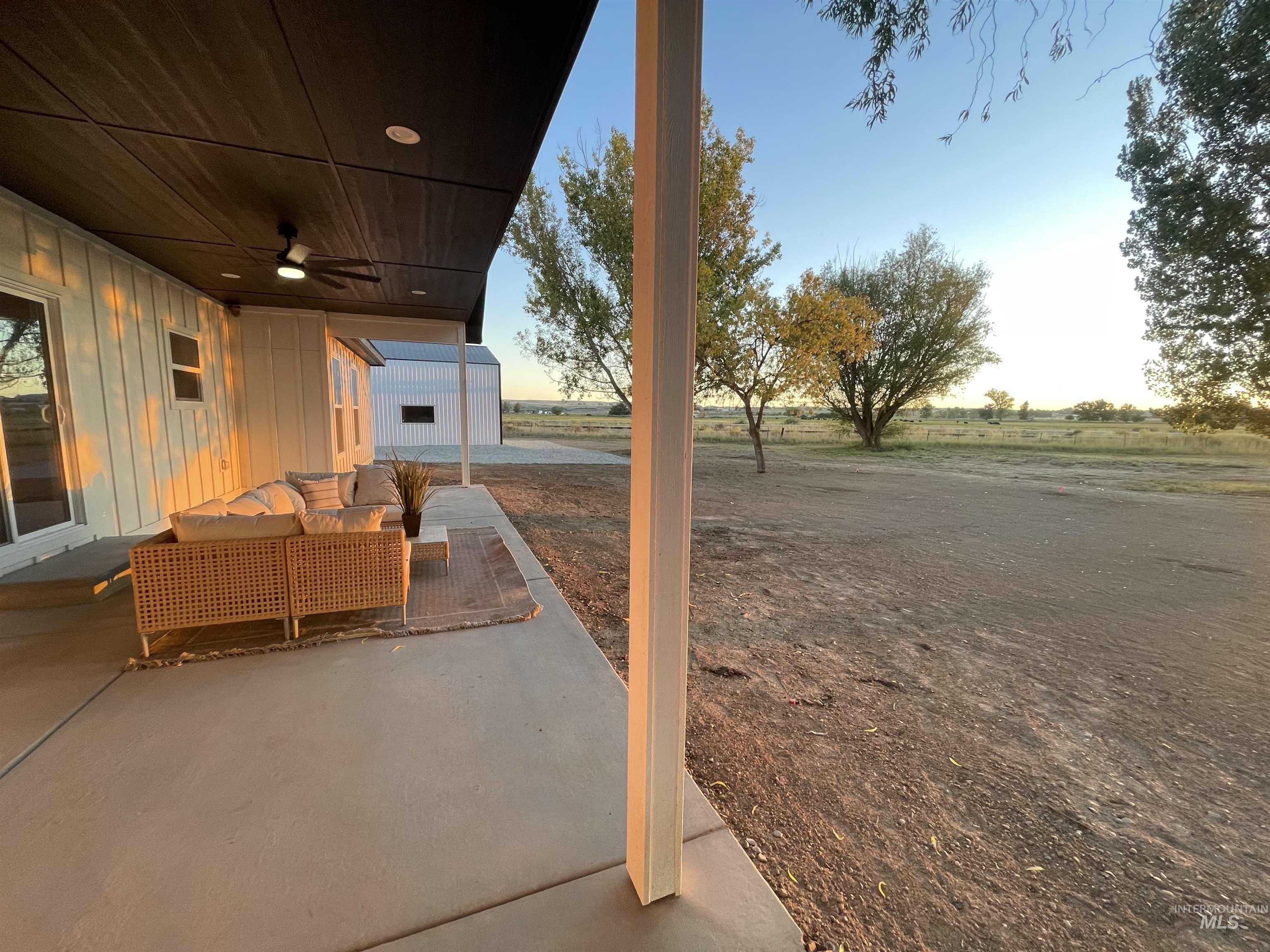 View of patio featuring outdoor lounge area, ceiling fan, and an outbuilding