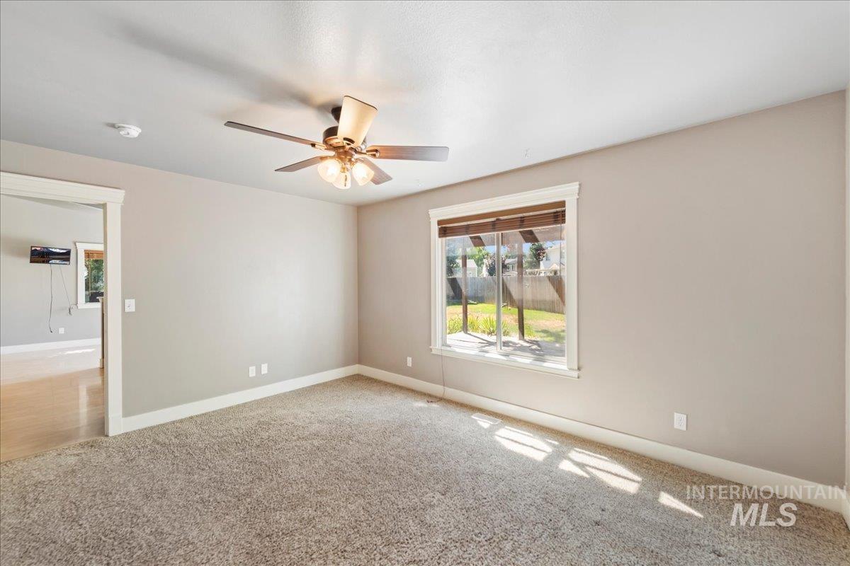 Empty room with light carpet and ceiling fan