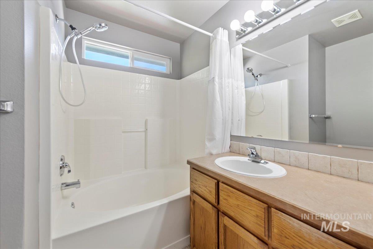 Full bath featuring shower / bath combo with shower curtain and vanity