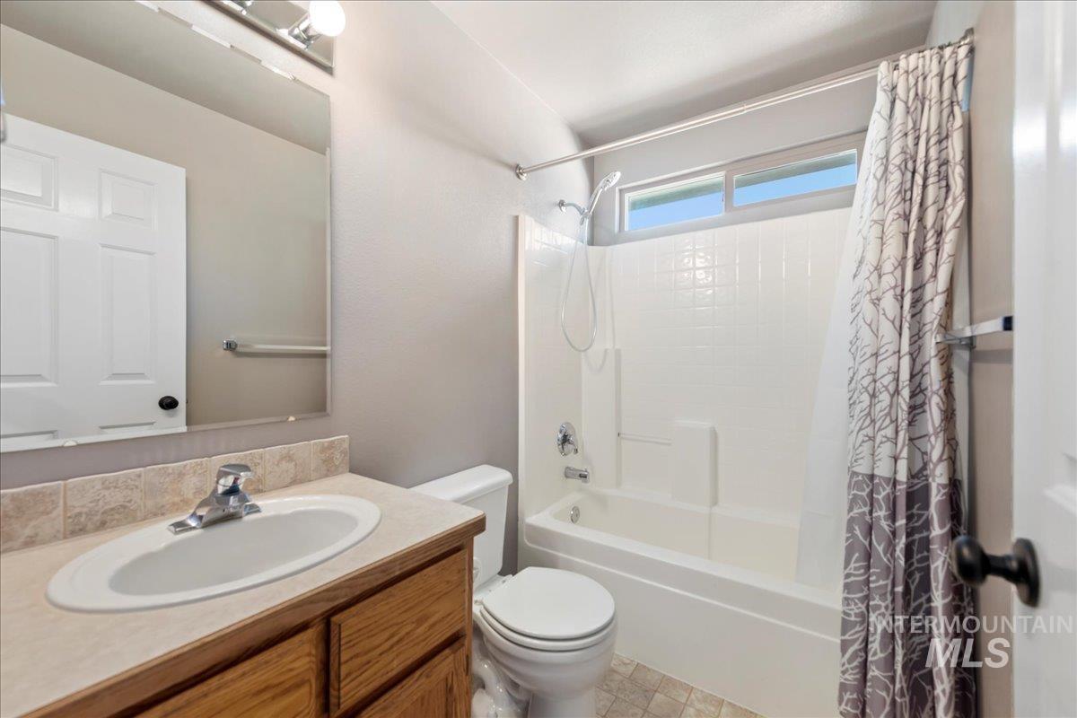 Full bath featuring shower / bathtub combination with curtain and vanity