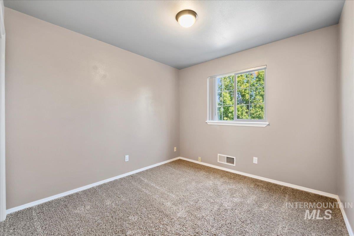 Carpeted empty room featuring baseboards