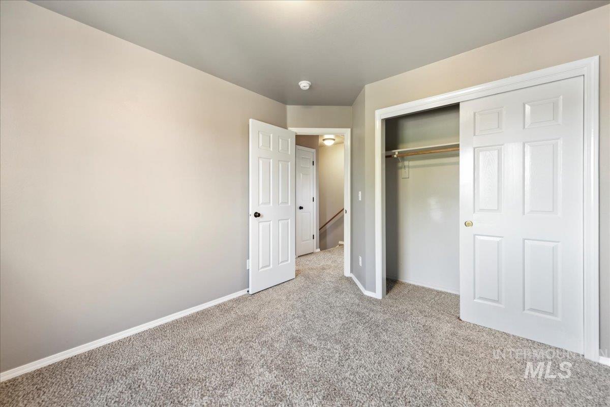 Unfurnished bedroom featuring light carpet and a closet