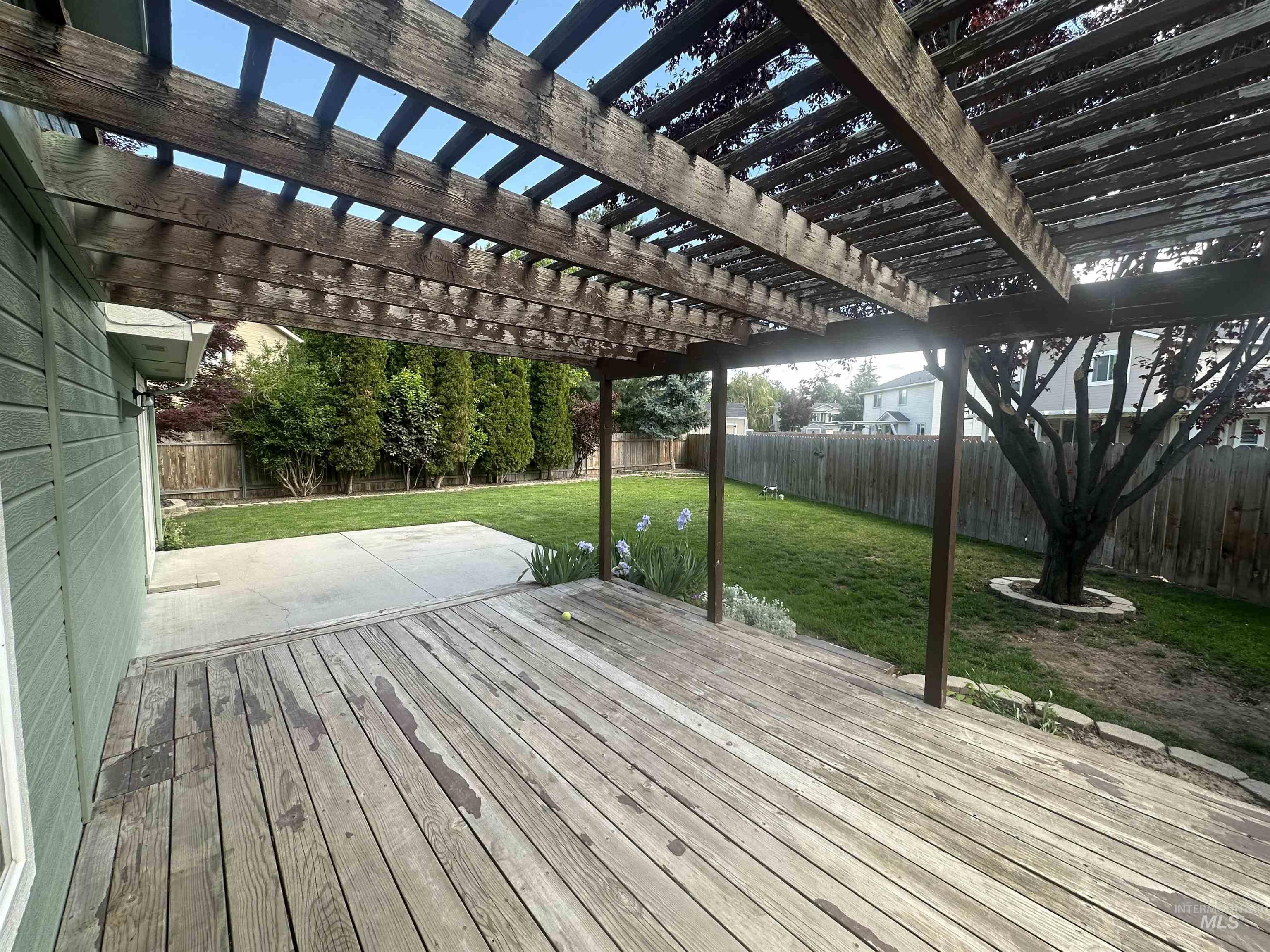 Deck with a fenced backyard, a pergola, and a patio area