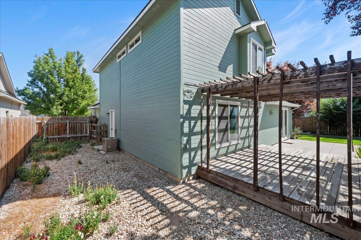 View of side of home with a pergola, a fenced backyard, and a patio