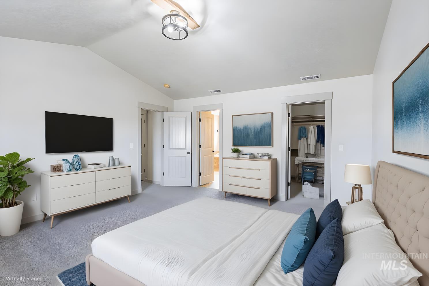 Bedroom featuring carpet, vaulted ceiling, and a walk in closet