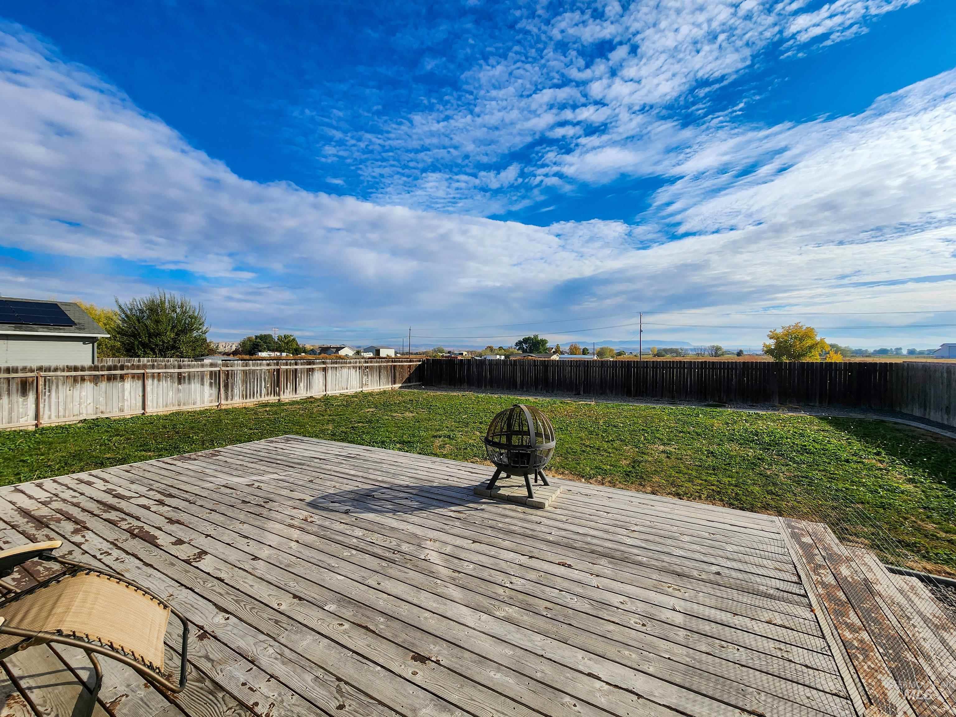Wooden deck featuring a fire pit and a fenced backyard