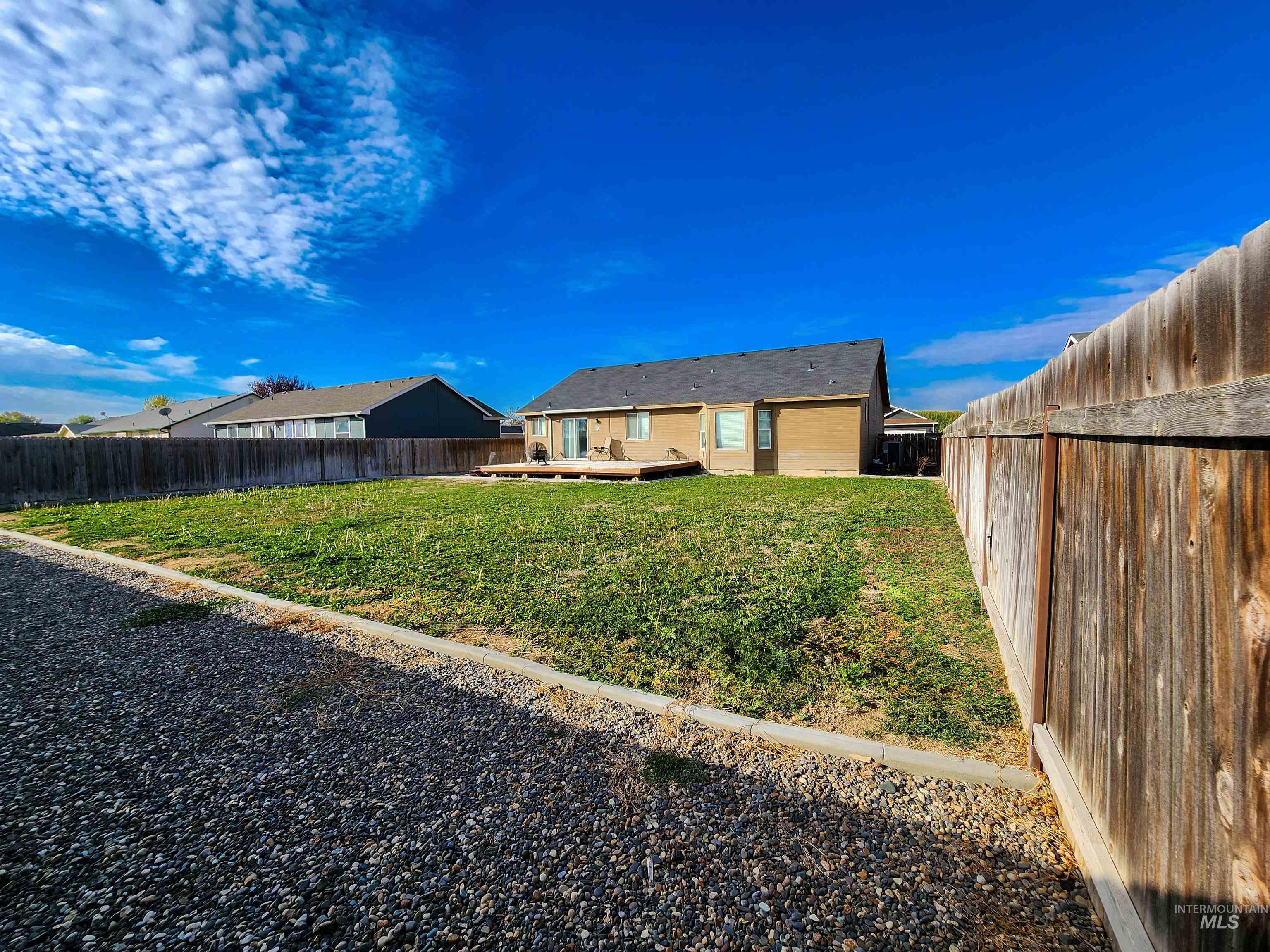 Back of house featuring a fenced backyard and a deck