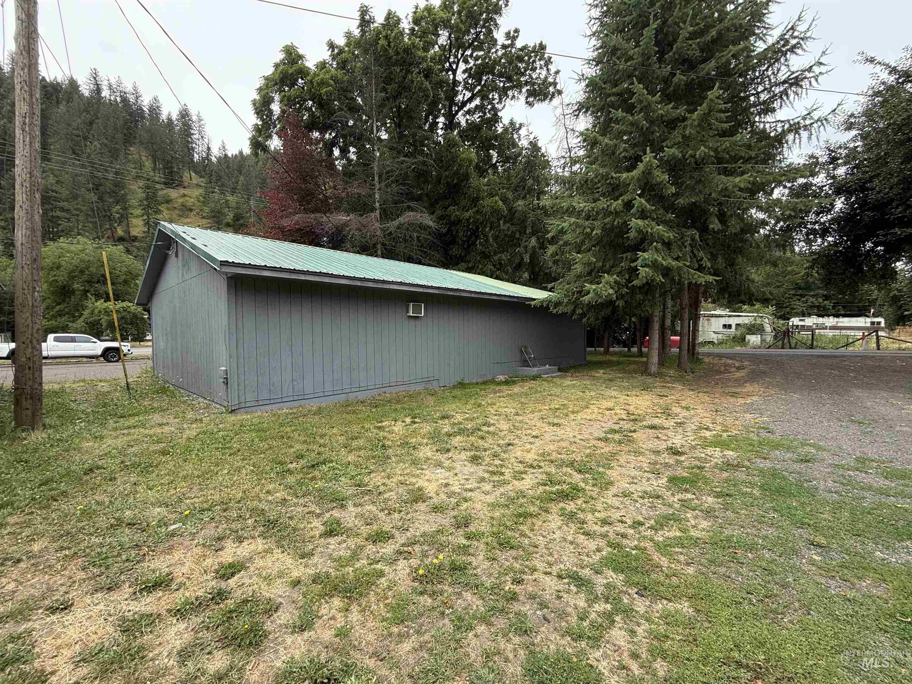 View of side of home featuring a yard and a metal roof