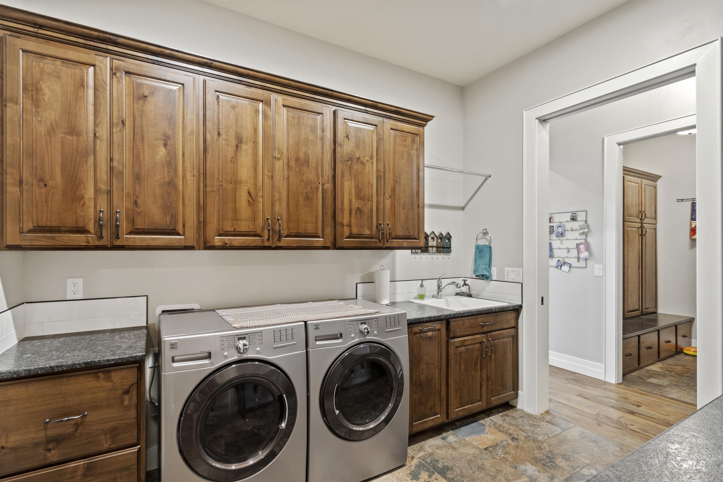Laundry room featuring cabinet space, separate washer and dryer, and light stone finish flooring