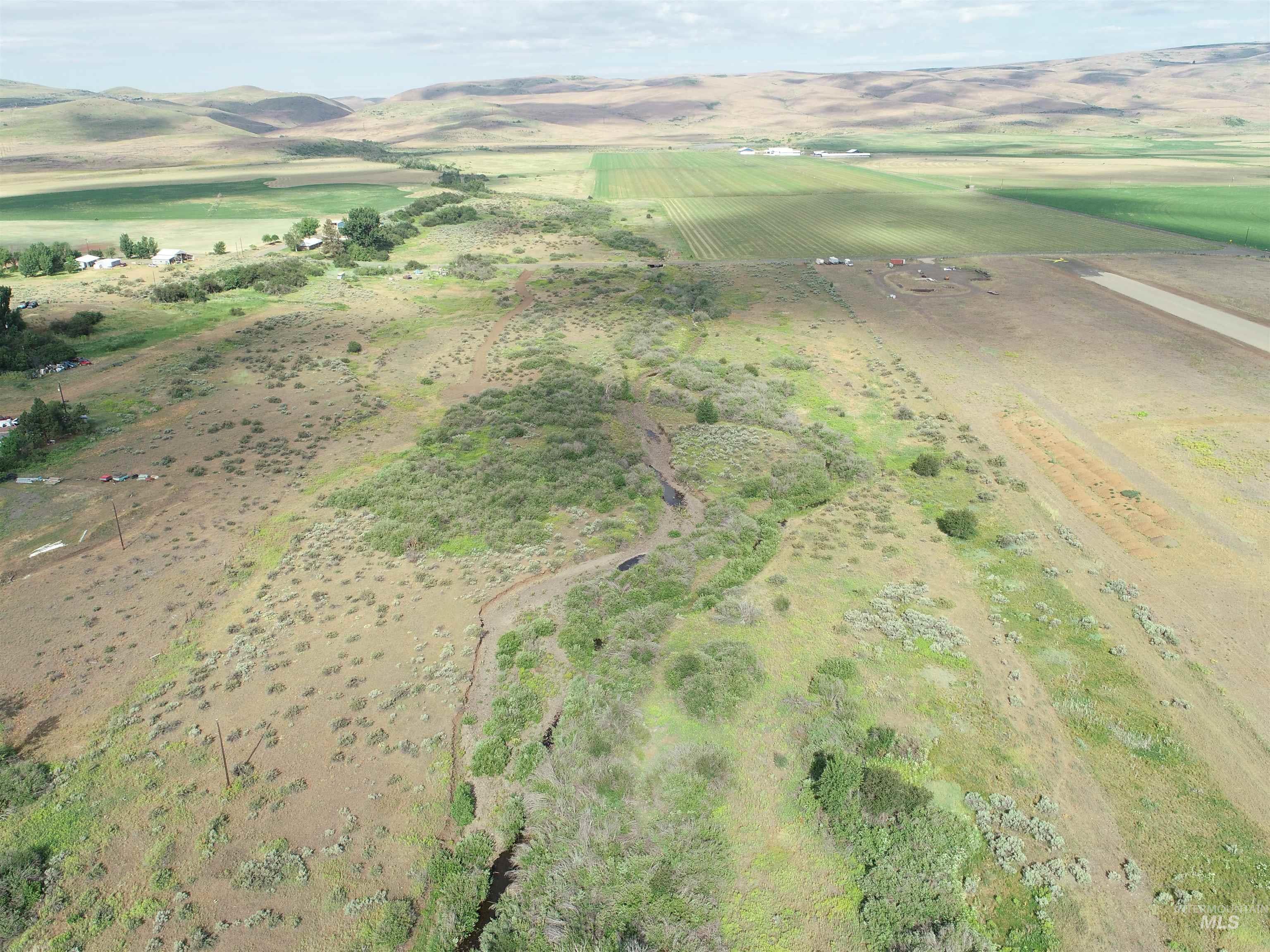 Aerial overview of property's location featuring rural landscape and a mountainous background