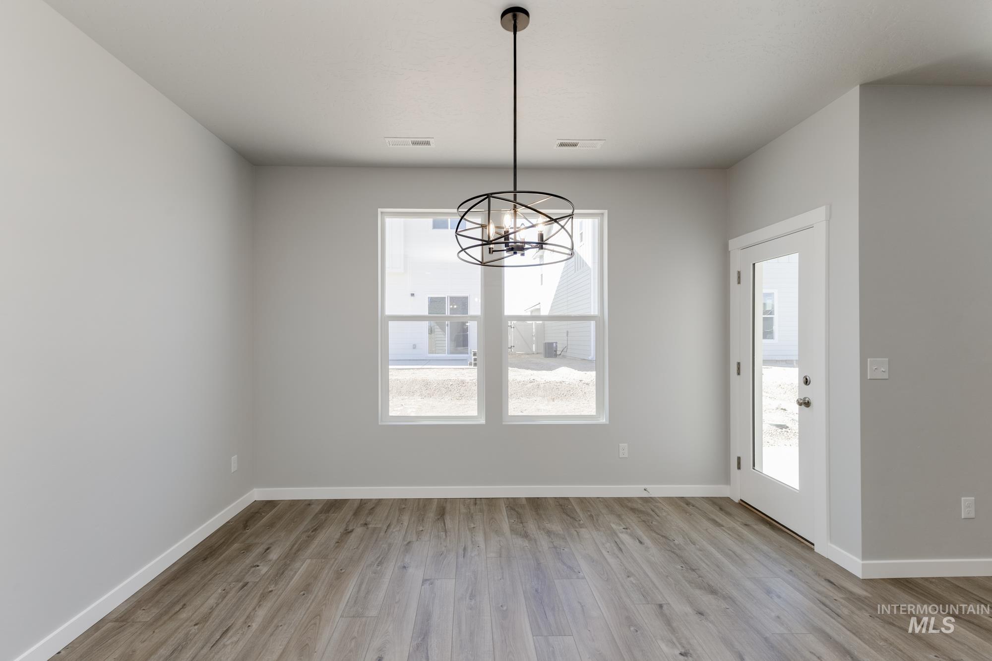 Unfurnished dining area featuring light wood-style floors and a chandelier
