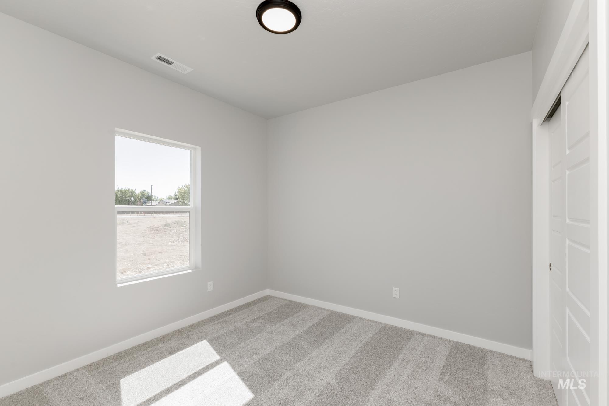 Empty room with light carpet and baseboards