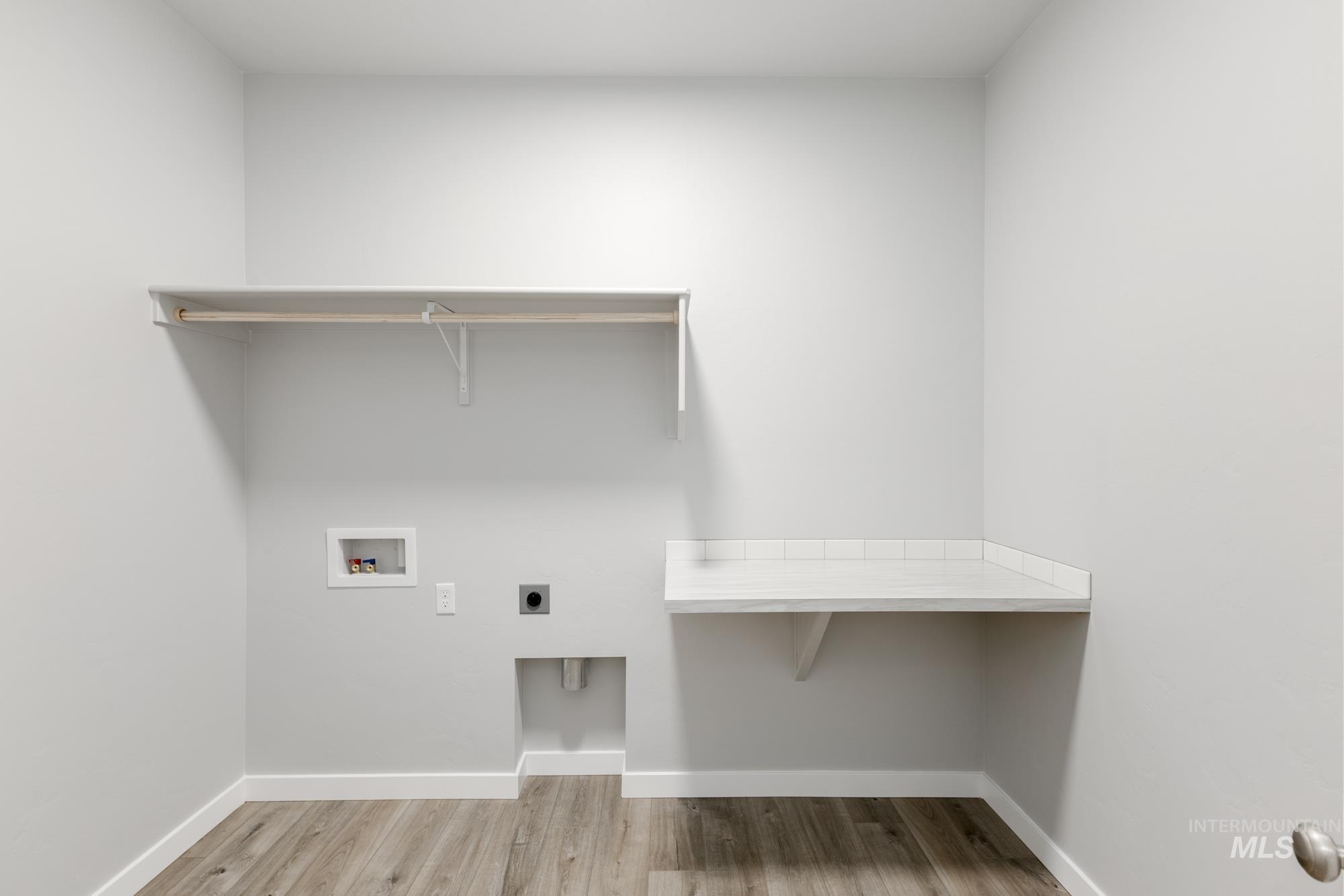 Laundry area with electric dryer hookup, washer hookup, and wood finished floors