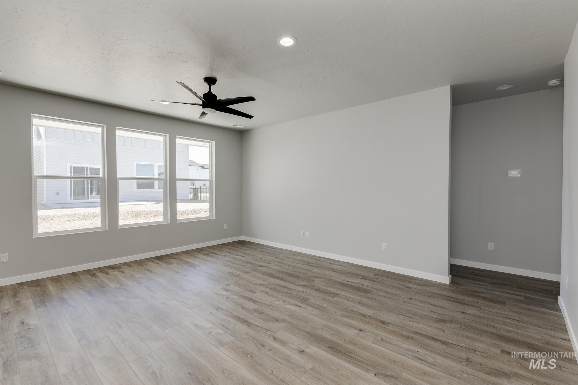 Empty room with ceiling fan, wood finished floors, and recessed lighting