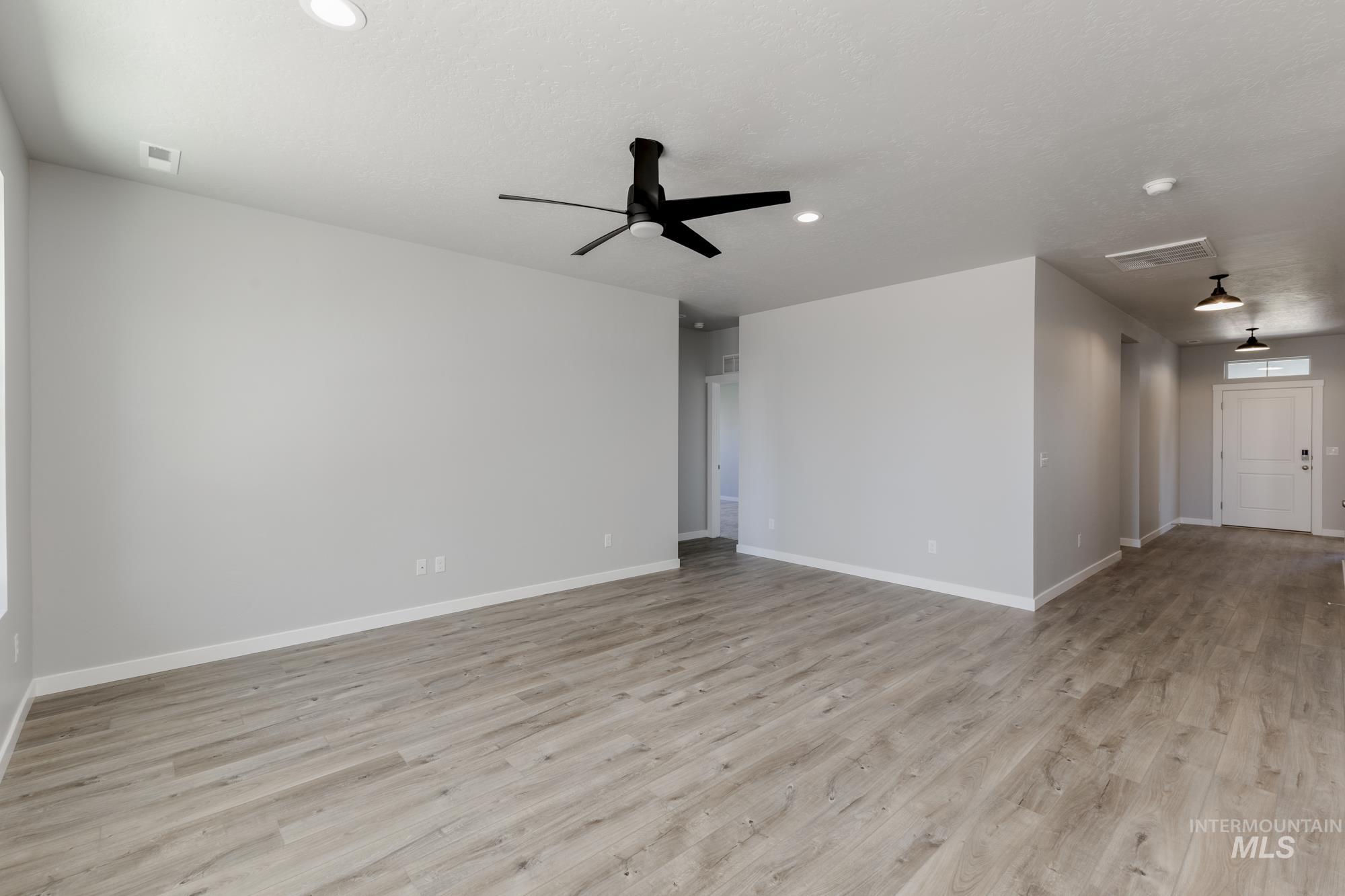 Unfurnished living room featuring wood finished floors, ceiling fan, and recessed lighting