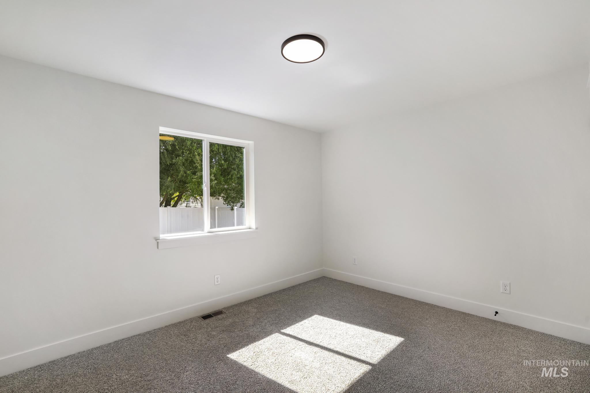Carpeted spare room with baseboards