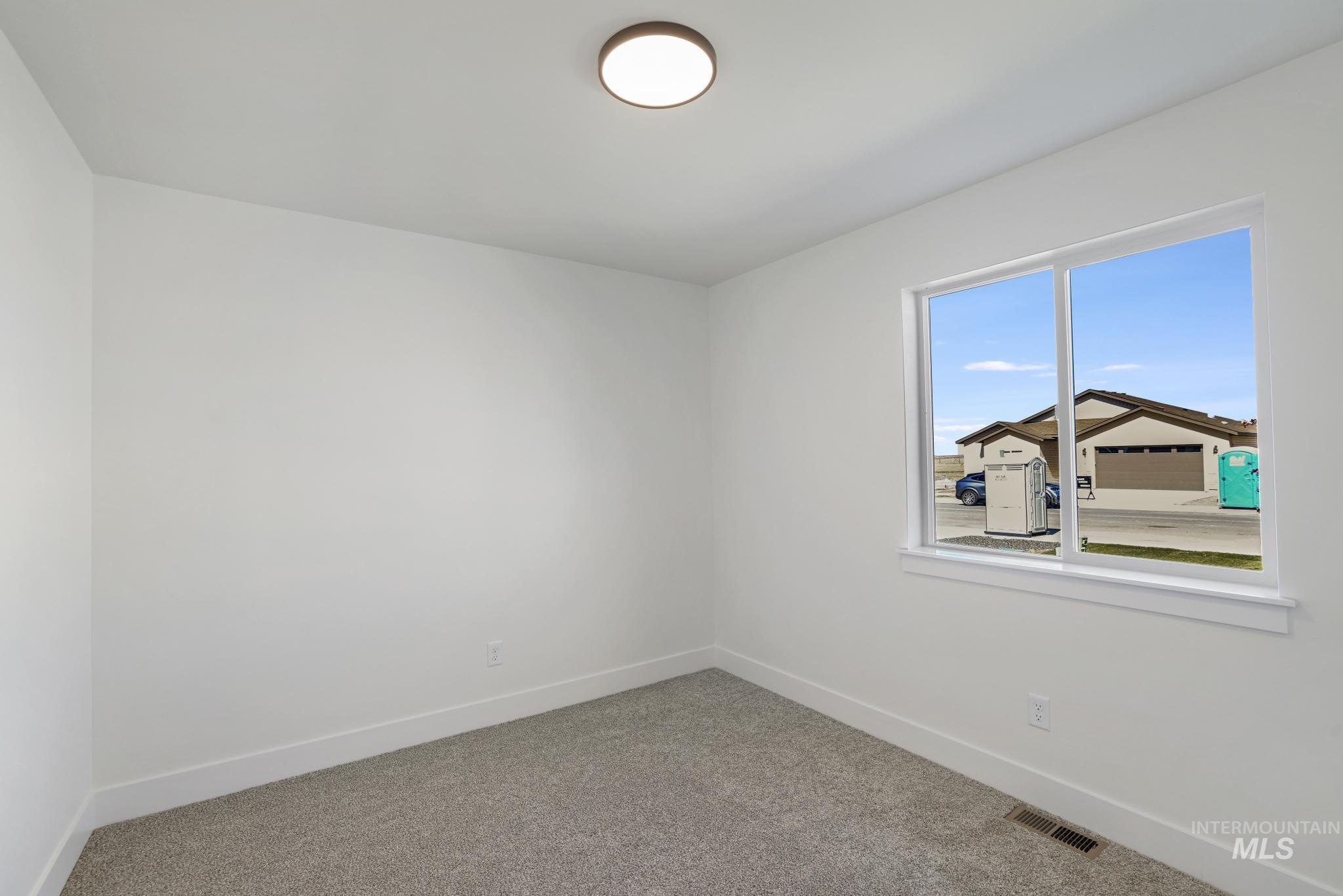 Carpeted empty room featuring baseboards