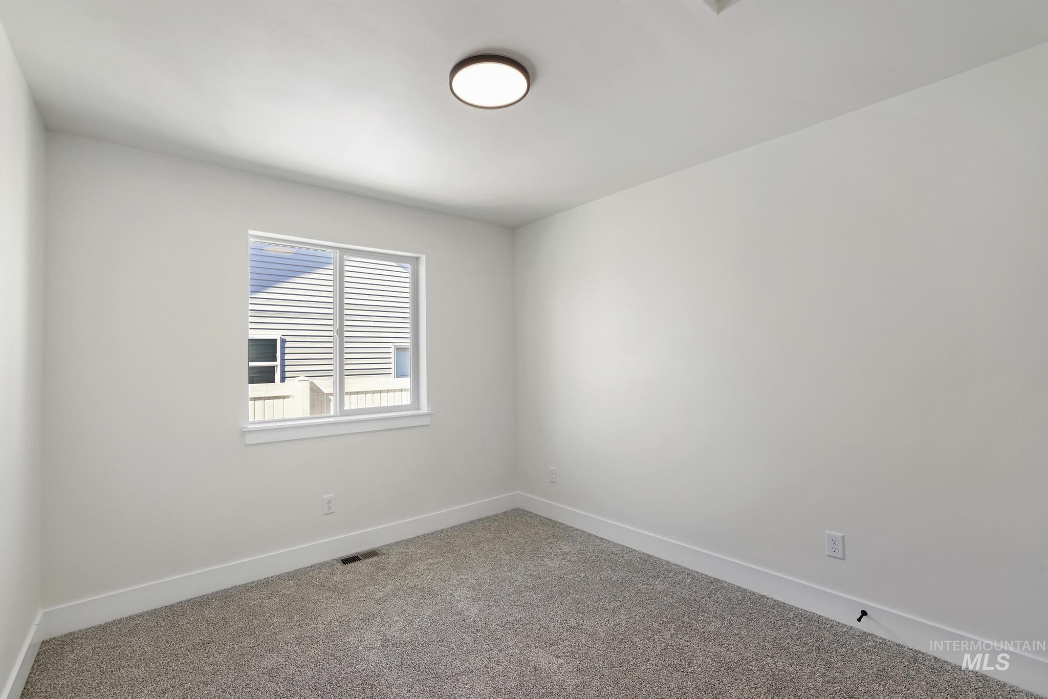 Carpeted spare room with baseboards
