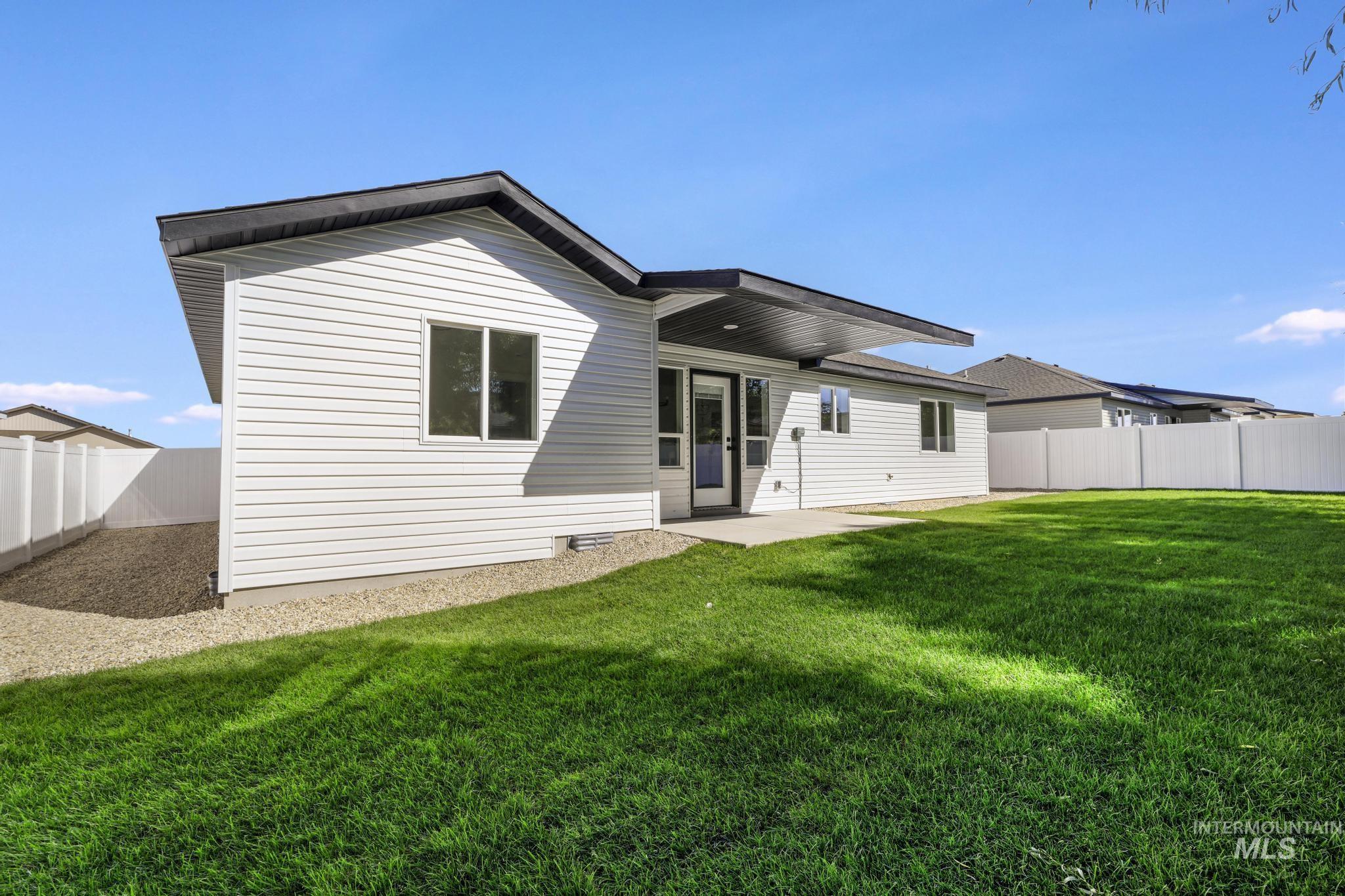Rear view of house with a fenced backyard and a patio area