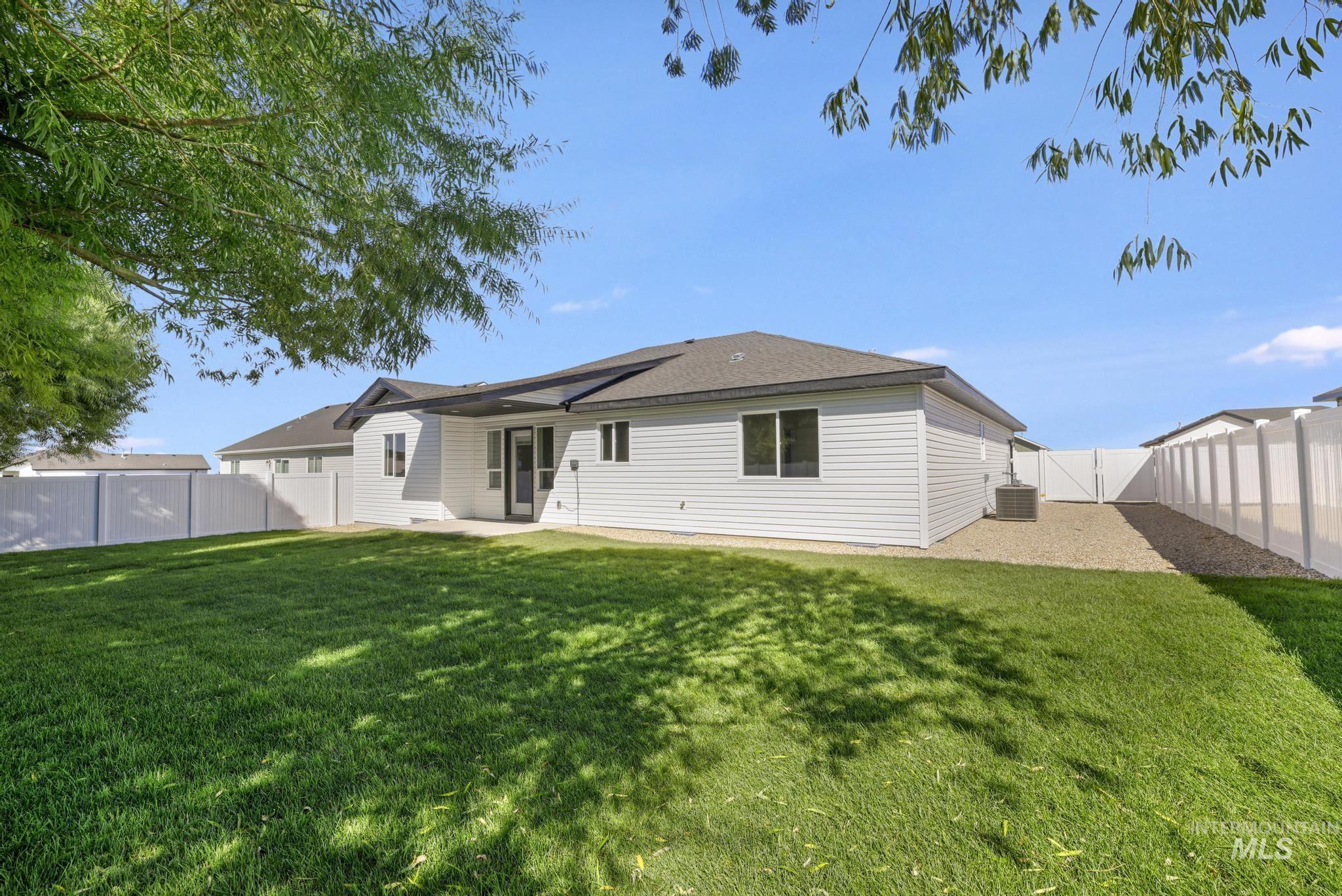 Back of house with a patio, a fenced backyard, and a gate