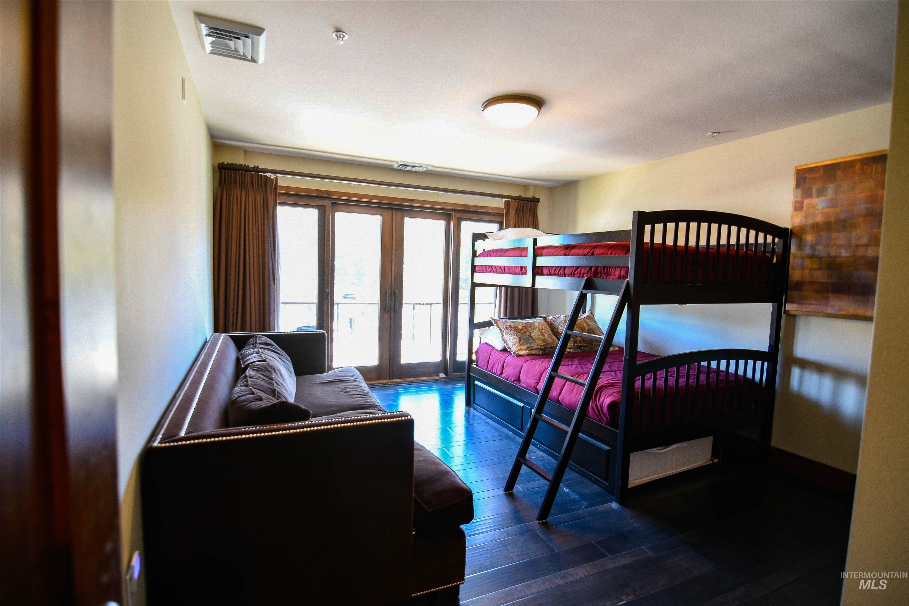 Bedroom with dark wood-style flooring, access to outside, and french doors