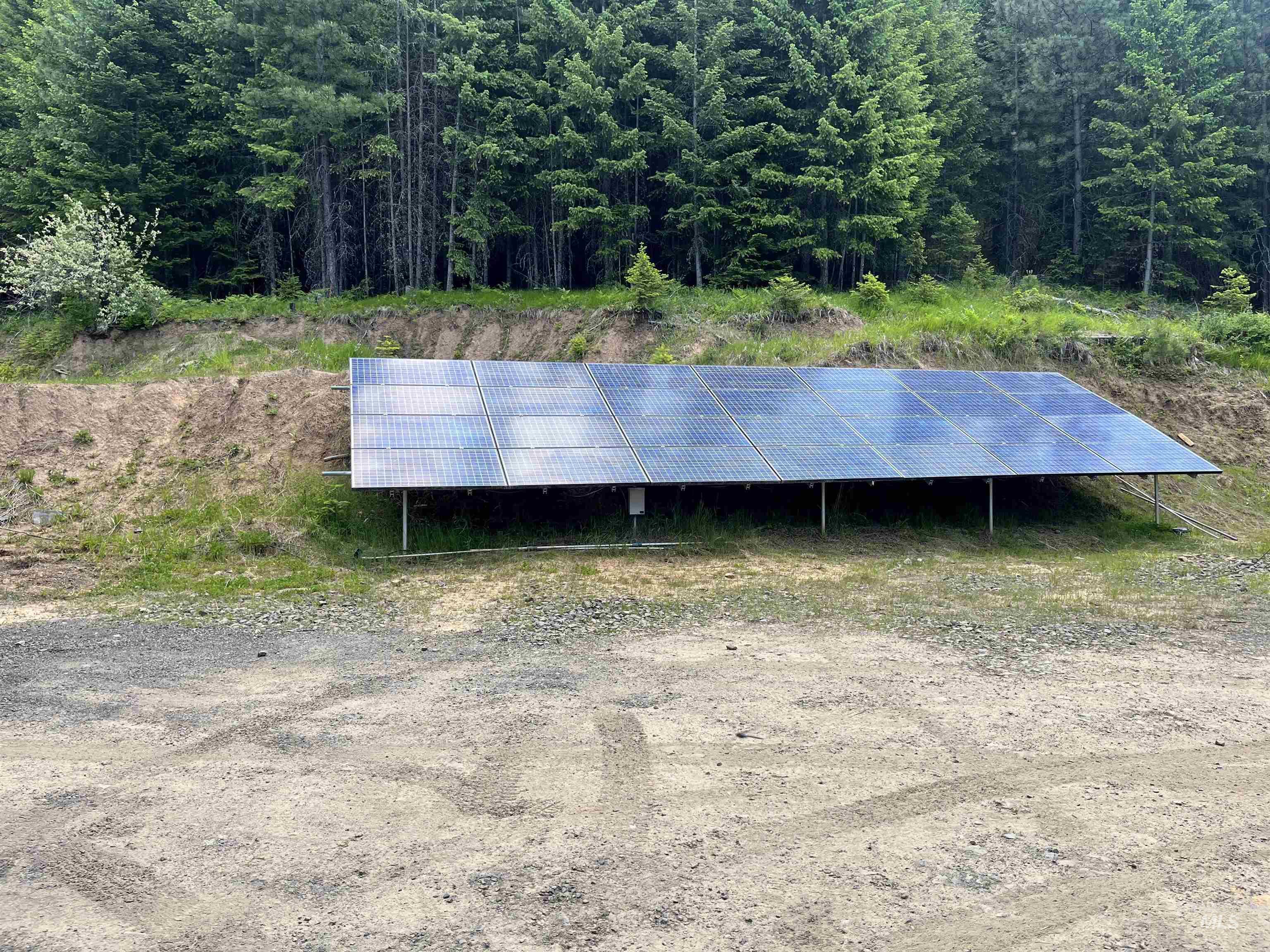 View of outbuilding with a forest view and solar panels