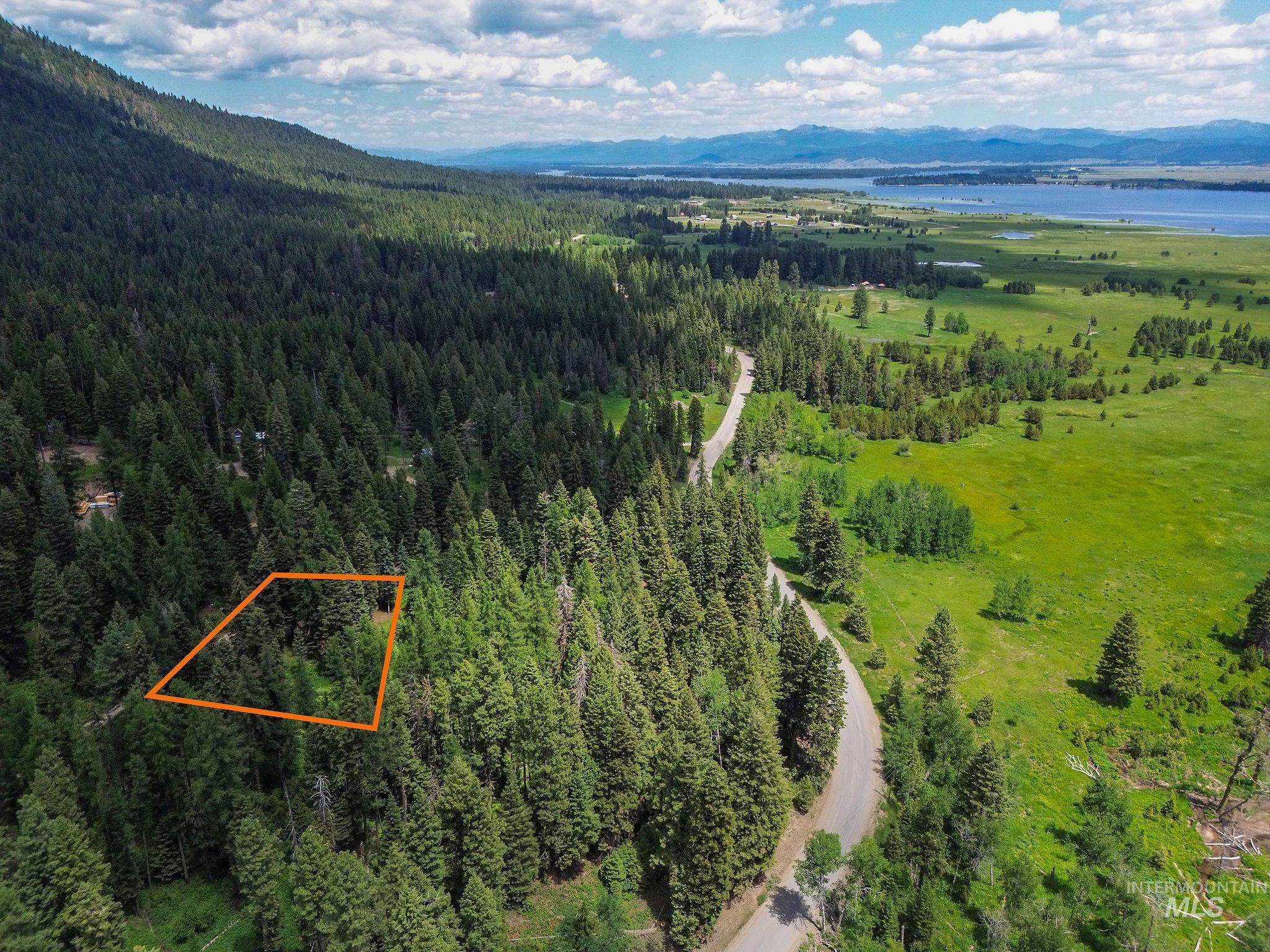 Aerial view of property's location with a water and mountain view and property boundaries highlighted