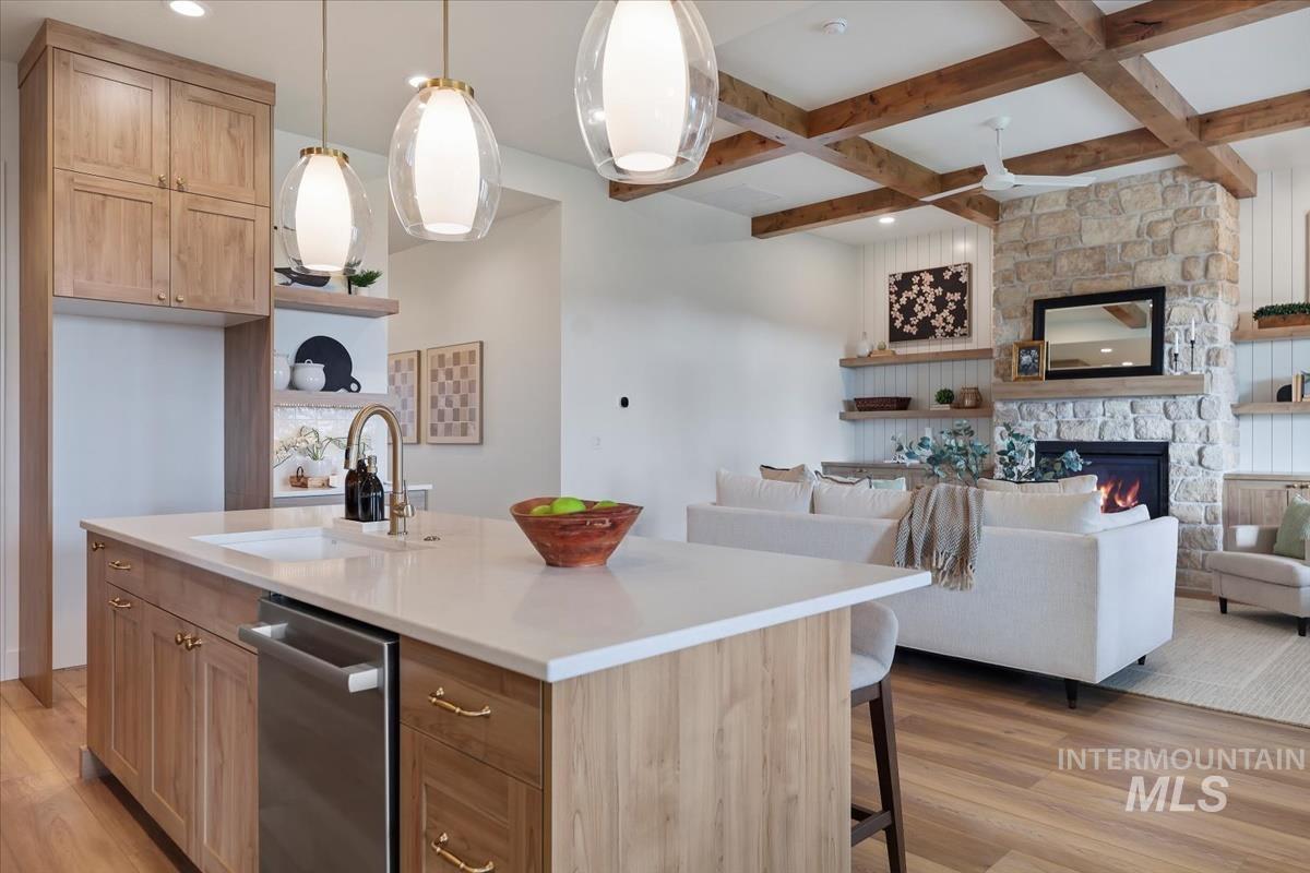 Kitchen with open floor plan, light wood finished floors, open shelves, beamed ceiling, and coffered ceiling