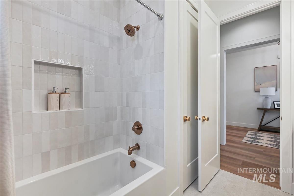 Bathroom with shower / bath combo and tile patterned floors