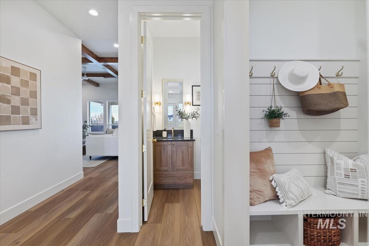Hall with wood finished floors, beam ceiling, coffered ceiling, and recessed lighting