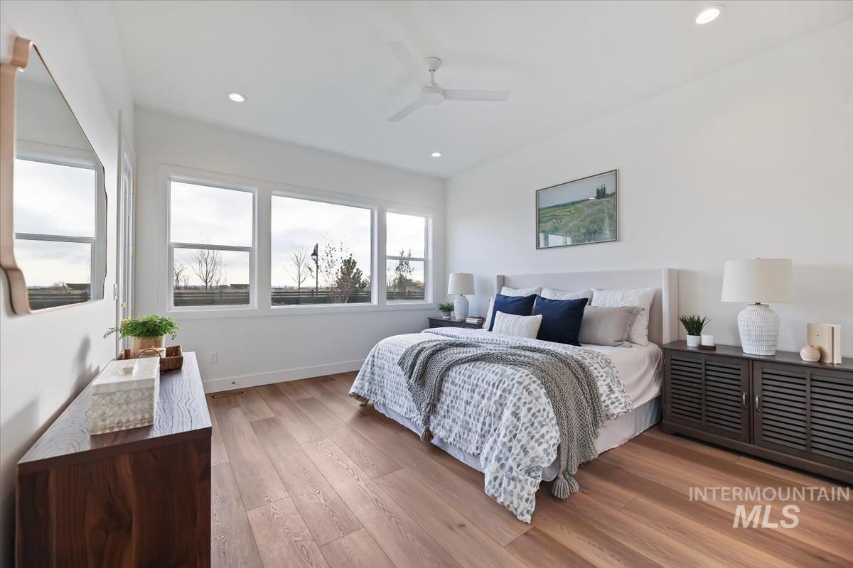 Bedroom with light wood finished floors, a ceiling fan, and recessed lighting