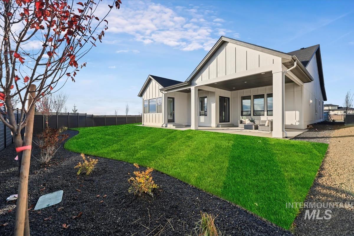 Back of property with board and batten siding and a fenced backyard