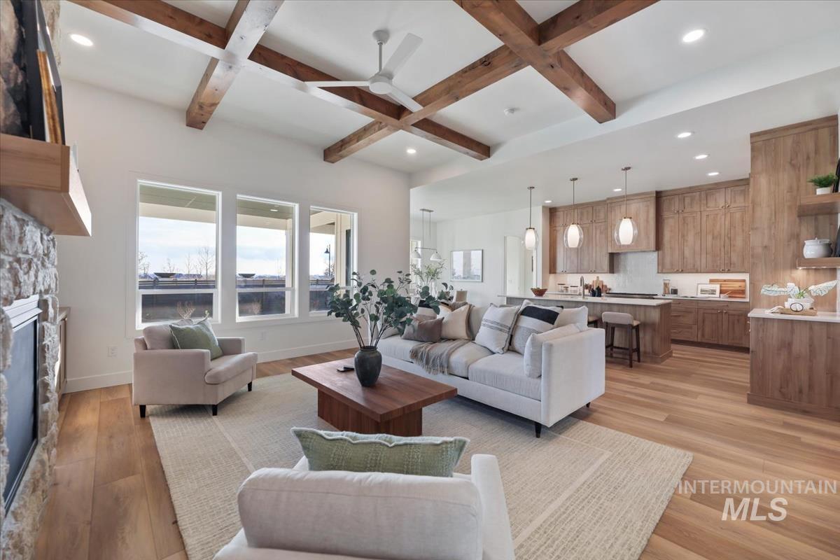 Living area featuring beamed ceiling, coffered ceiling, a fireplace, light wood-style flooring, and recessed lighting