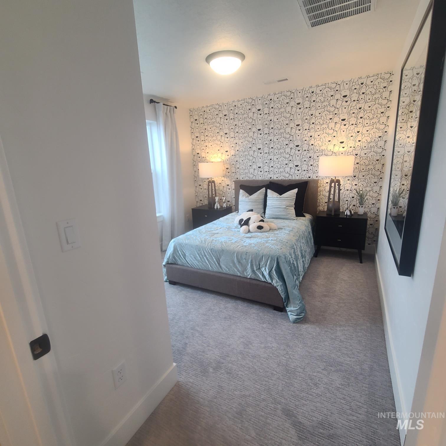 Carpeted bedroom with wallpapered walls and an accent wall
